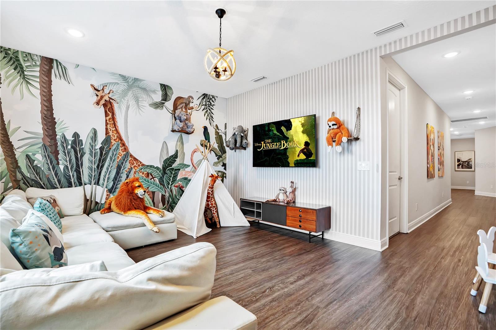 An inviting upstairs lounge with spacious seating, television, and luxury vinyl plank flooring