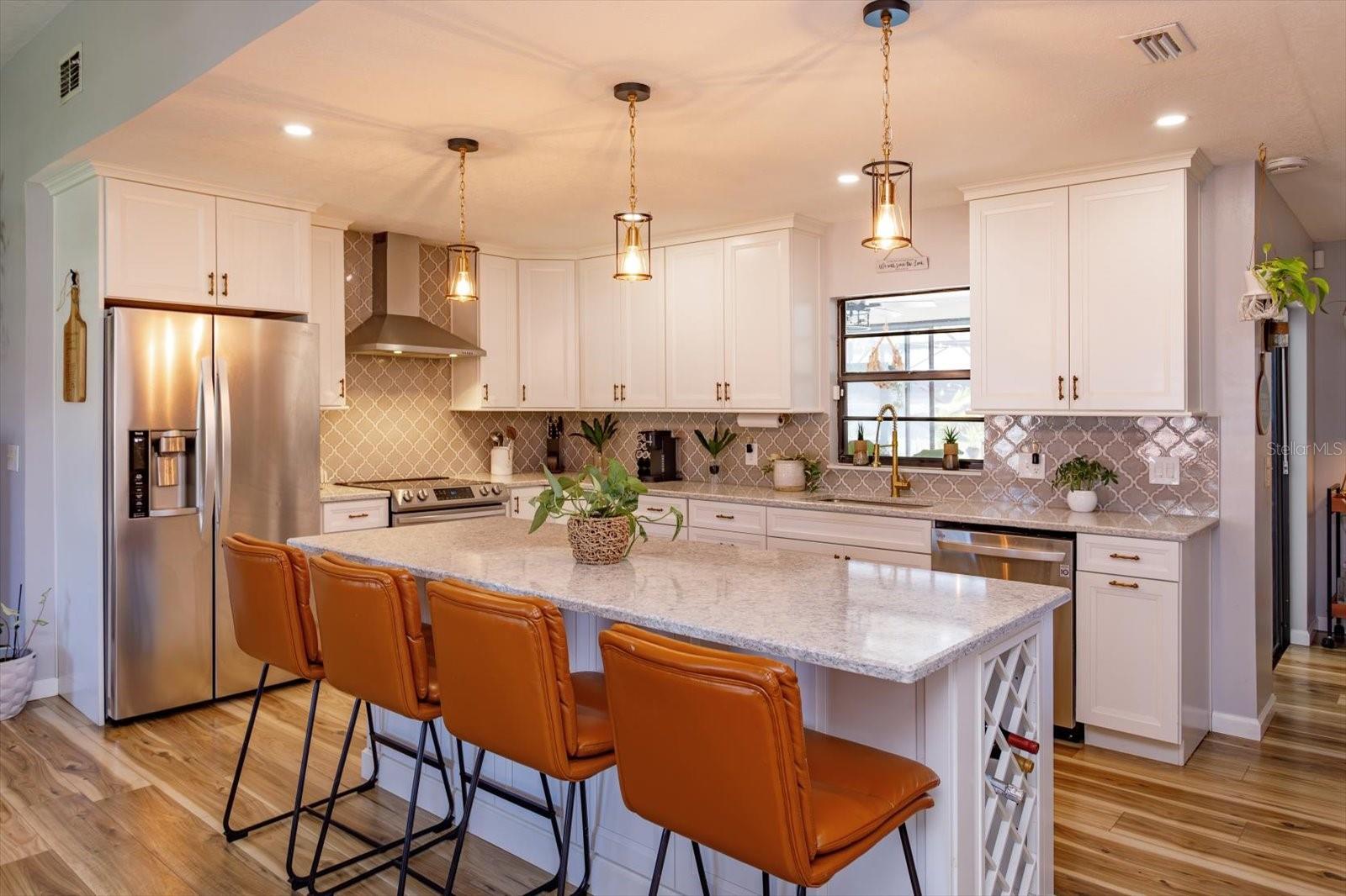 Beautifully renovated kitchen with shaker cabinets and quartz counters