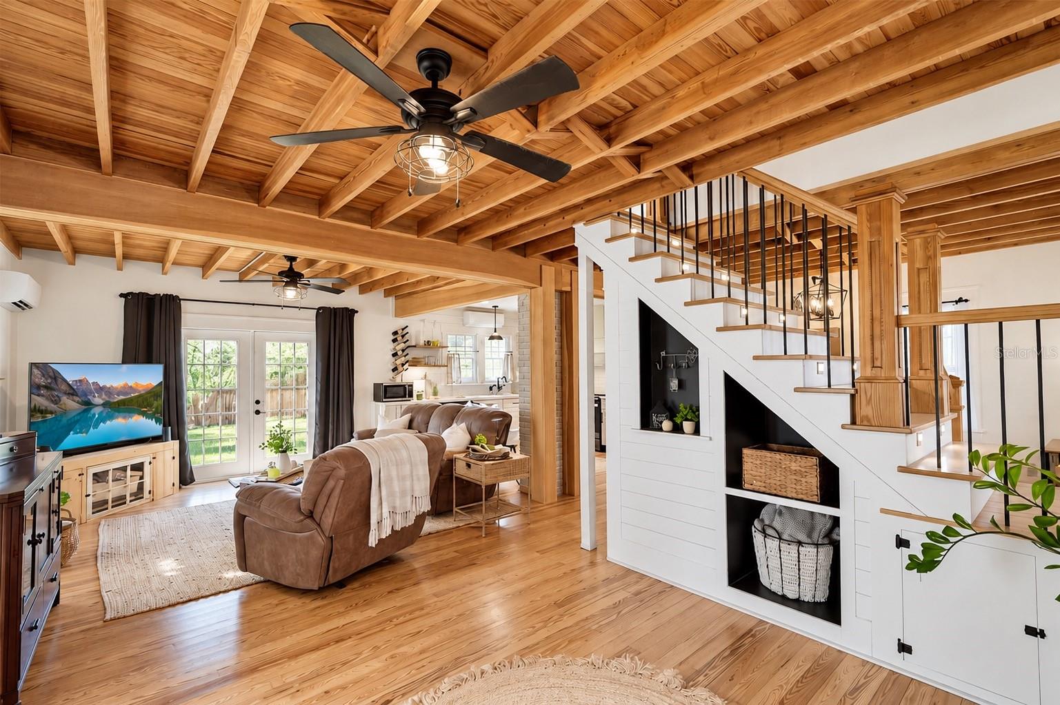 OPEN-CONCEPT LIVING SPACE featuring beautiful EXPOSED WOOD BEAM CEILINGS, hardwood floors, and custom BUILT-IN SHELVING AND STORAGE beneath the staircase. FRENCH DOORS provide abundant natural light and lead to the SPACIOUS, FULLY FENCED BACKYARD. The living area flows seamlessly into the OPEN KITCHEN, creating a wonderful space for everyday living and entertaining! OPEN-CONCEPT LIVING SPACE featuring beautiful EXPOSED WOOD BEAM CEILINGS, hardwood floors, and custom BUILT-IN SHELVING AND STORAGE beneath the staircase. FRENCH DOORS provide abundant natural light and lead to the SPACIOUS, FULLY FENCED BACKYARD. The living area flows seamlessly into the OPEN KITCHEN, creating a wonderful space for everyday living and entertaining!