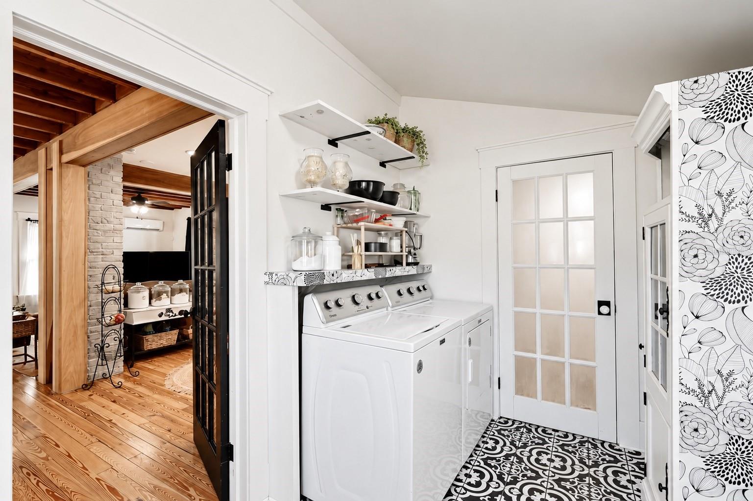 Conveniently located just off the kitchen, this charming INDOOR LAUNDRY ROOM features a washer and dryer, EXTRA OPEN SHELVING for storage and organization, and beautiful patterned tile flooring. A lovely glass-paneled door leads directly into the FULL DOWNSTAIRS BATHROOM, offering easy access to the fenced backyard and barn!
