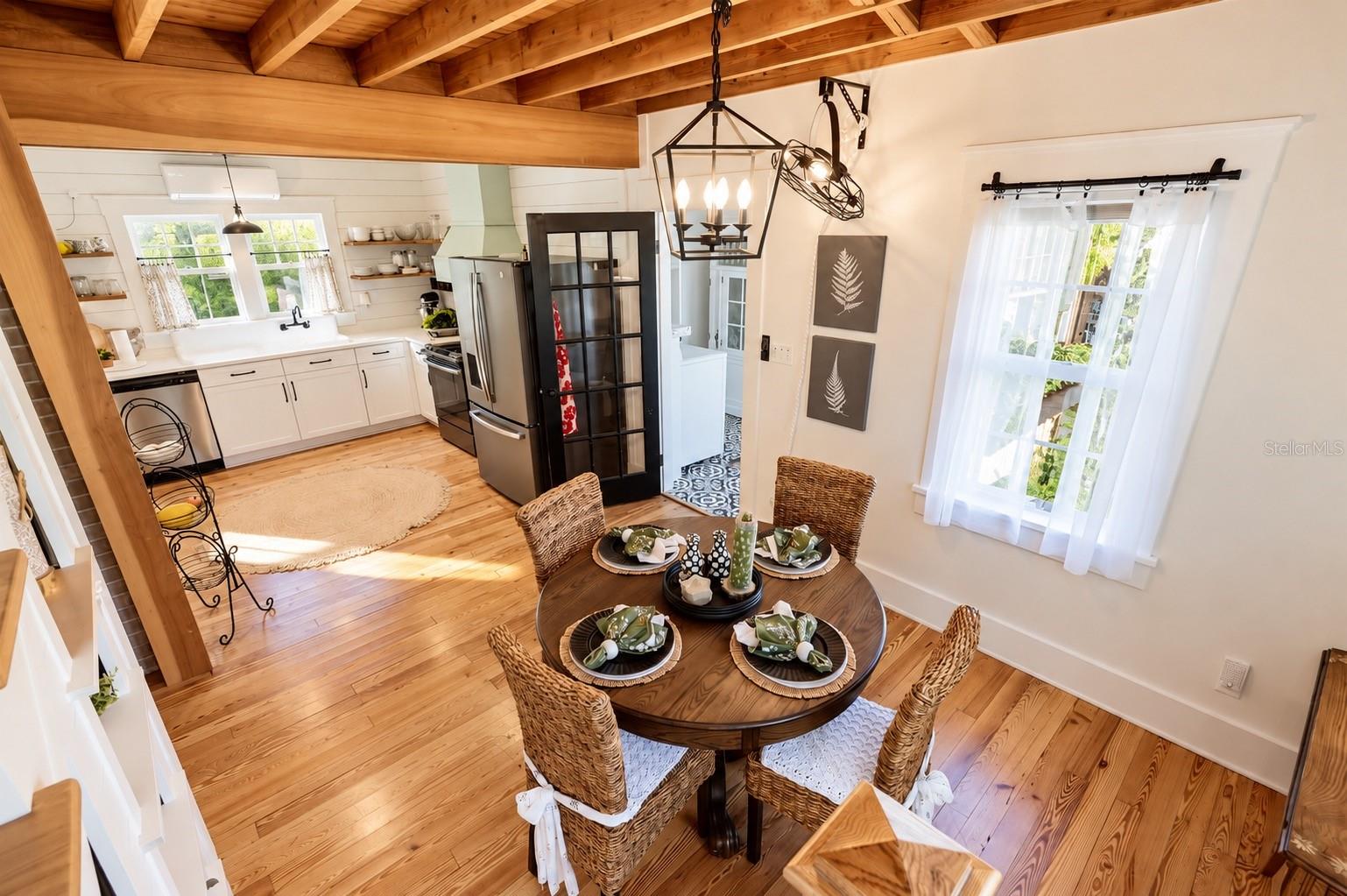 FARMHOUSE-STYLE DINING AREA featuring gorgeous exposed wood beam ceilings, beautiful wood flooring, a stylish lantern chandelier, and abundant natural light! OPEN TO THE BEAUTIFULLY UPDATED KITCHEN, creating a warm and inviting space for everyday dining and entertaining. FARMHOUSE-STYLE DINING AREA featuring gorgeous exposed wood beam ceilings, beautiful wood flooring, a stylish lantern chandelier, and abundant natural light! OPEN TO THE BEAUTIFULLY UPDATED KITCHEN, creating a warm and inviting space for everyday dining and entertaining.