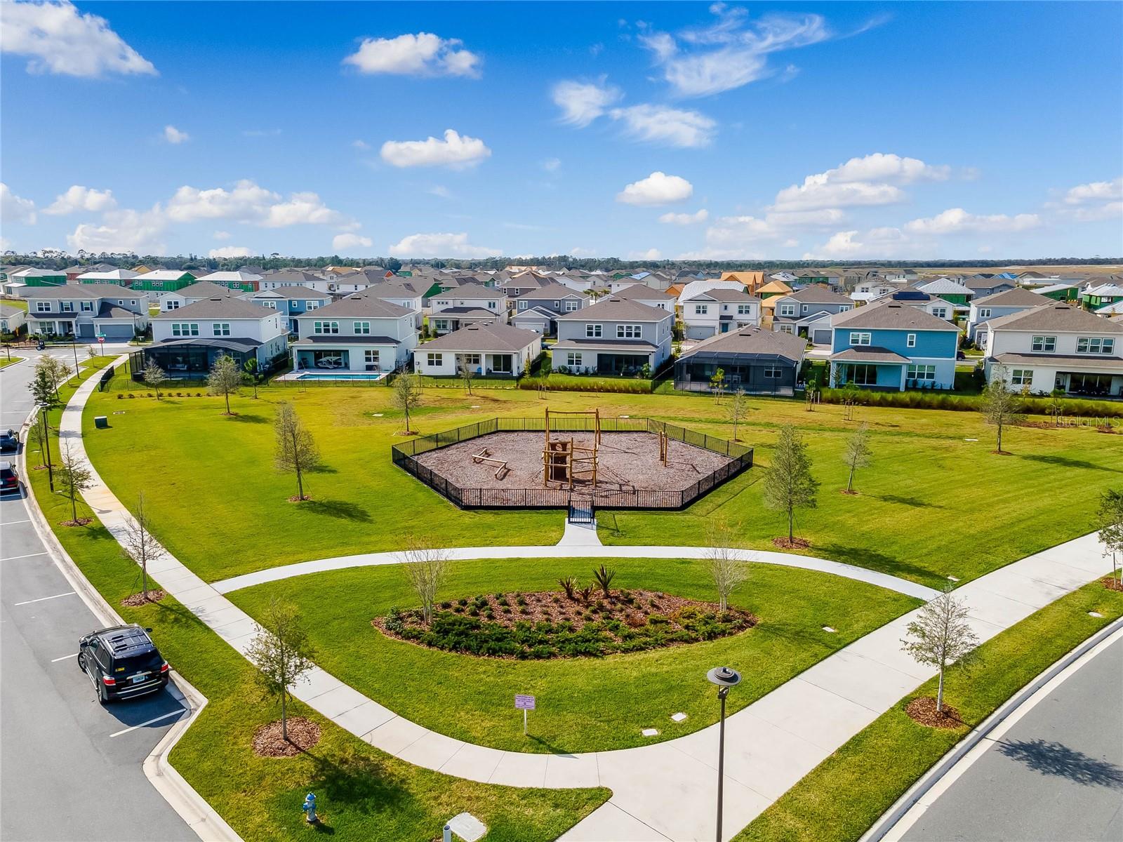 Landscaped neighborhood park with winding walking paths in Laureate Park.