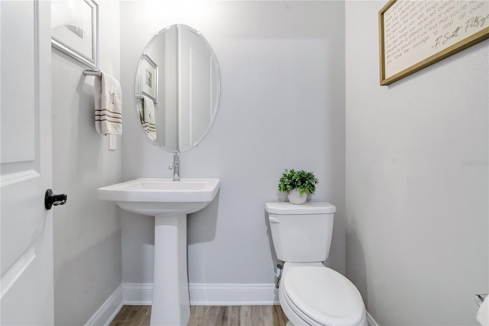 Convenient half bath with pedestal sink and modern finishes.