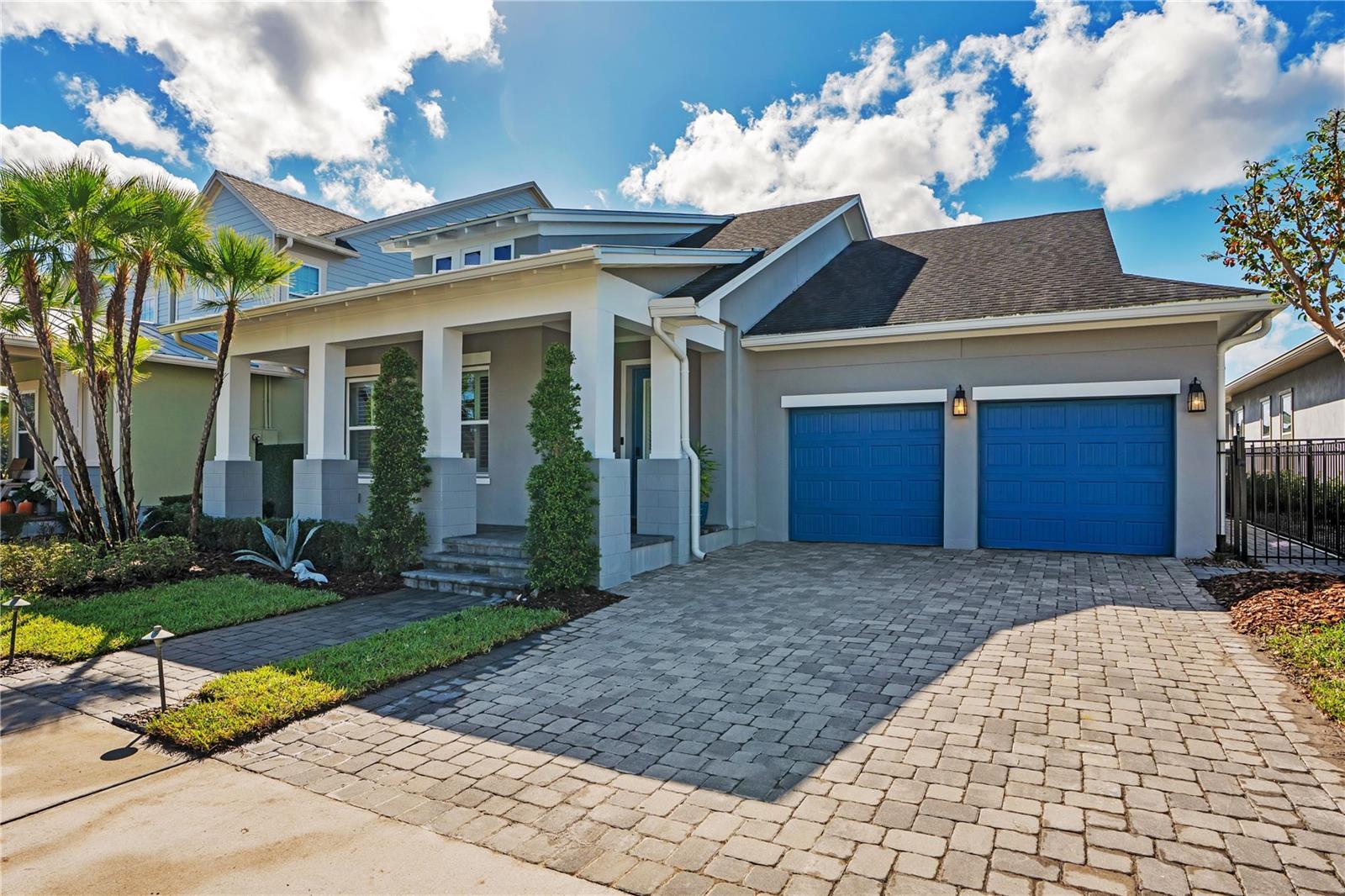 Front elevation with paver driveway, two car garage with EV charging, and covered front porch.