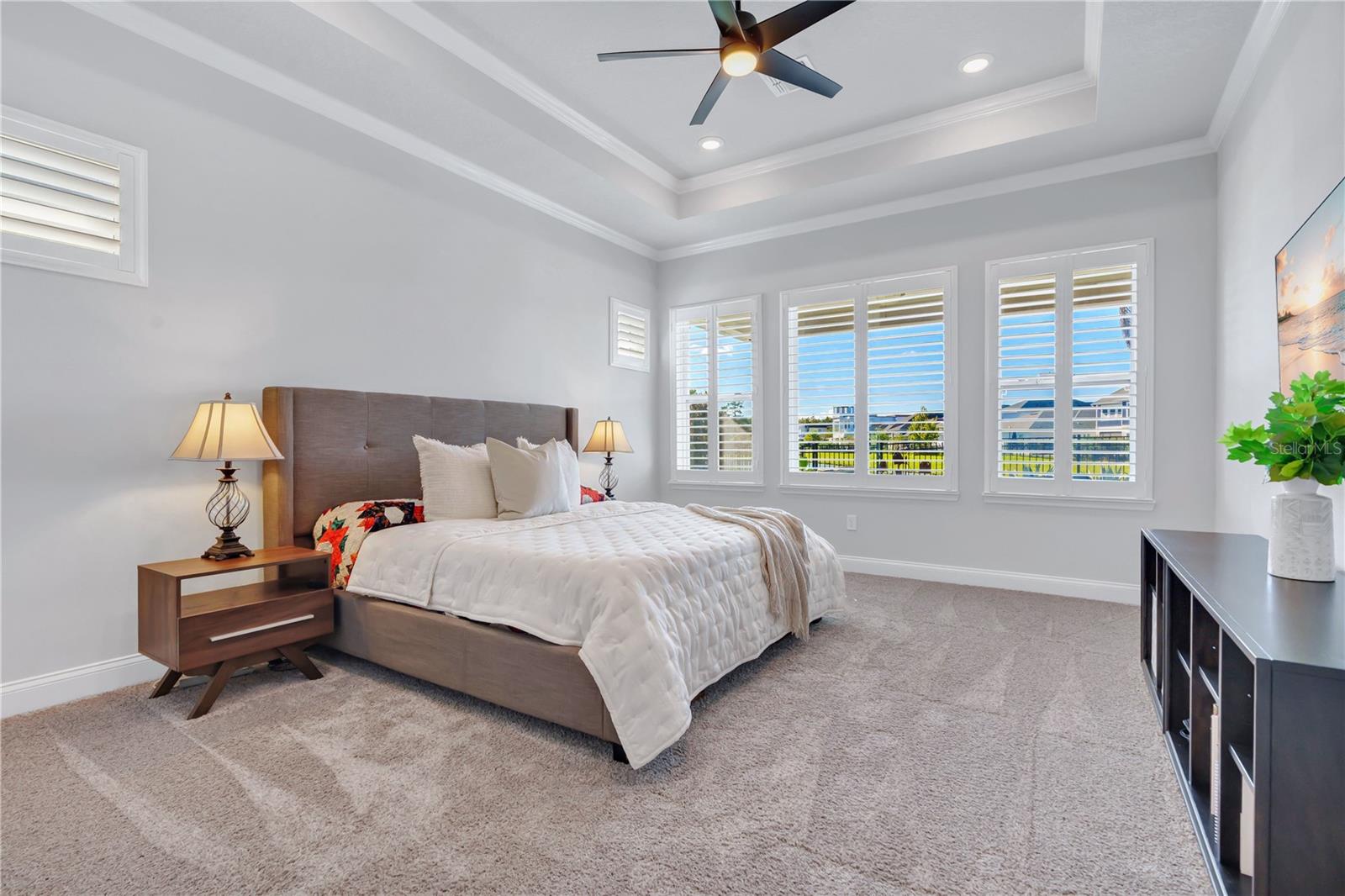 Primary bedroom with a tray ceiling and plenty of natural light, privately positioned in the split bedroom floor plan.