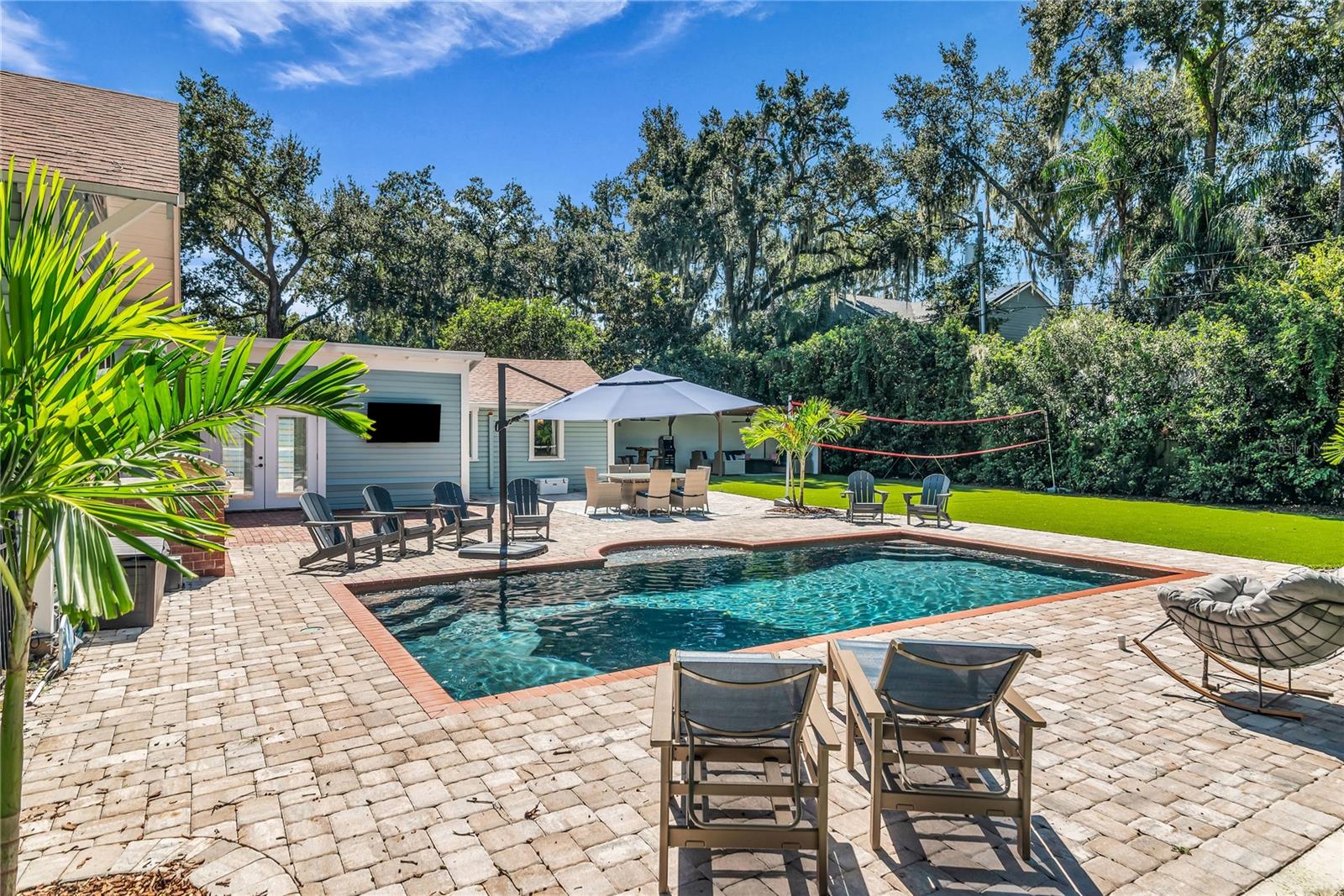 The enormous fully fenced backyard is designed for year-round enjoyment with a gas-heated saltwater sport pool, outdoor kitchen, expansive brick paved deck, detached covered lanai, and low-maintenance turf. The enormous fully fenced backyard is designed for year-round enjoyment with a gas-heated saltwater sport pool, outdoor kitchen, expansive brick paved deck, detached covered lanai, and low-maintenance turf.