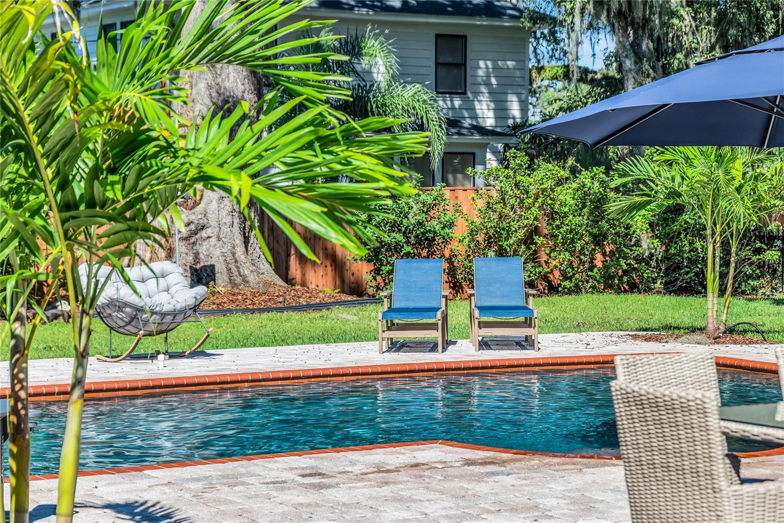The enormous fully fenced backyard is designed for year-round enjoyment with a gas-heated saltwater sport pool, outdoor kitchen, expansive brick paved deck, detached covered lanai, and low-maintenance turf.