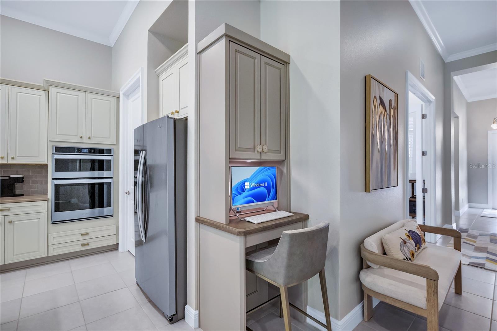 Convenient built-in computer workstation located just off the kitchen, featuring custom cabinetry and a dedicated workspace perfect for everyday tasks, organization, or working from home.