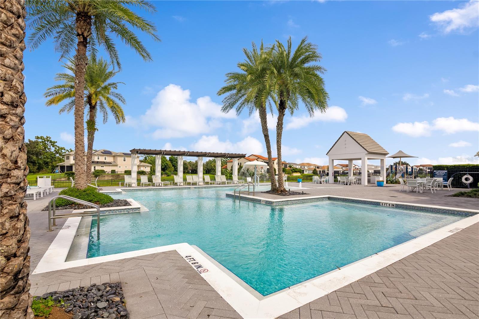 Relax and unwind at the stunning resort-style community pool surrounded by tropical landscaping.