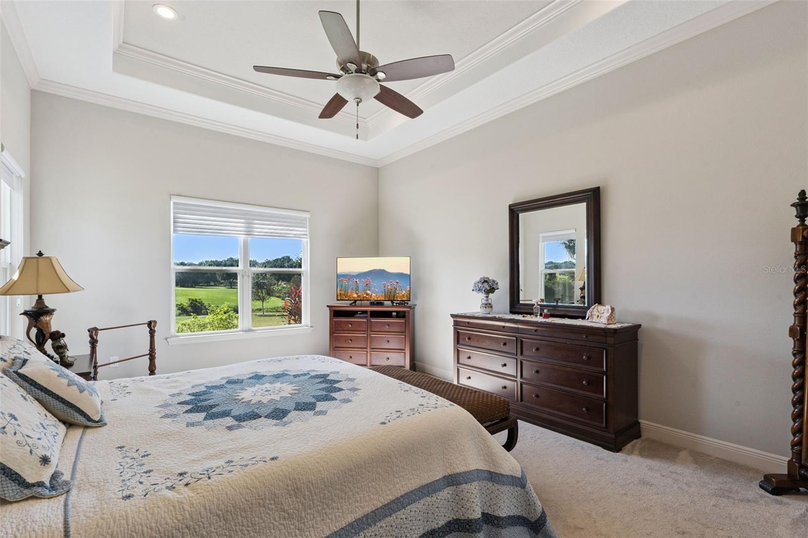 Spacious primary bedroom featuring a sophisticated trey ceiling, dual his-and-her closets, and a private en suite bathroom.