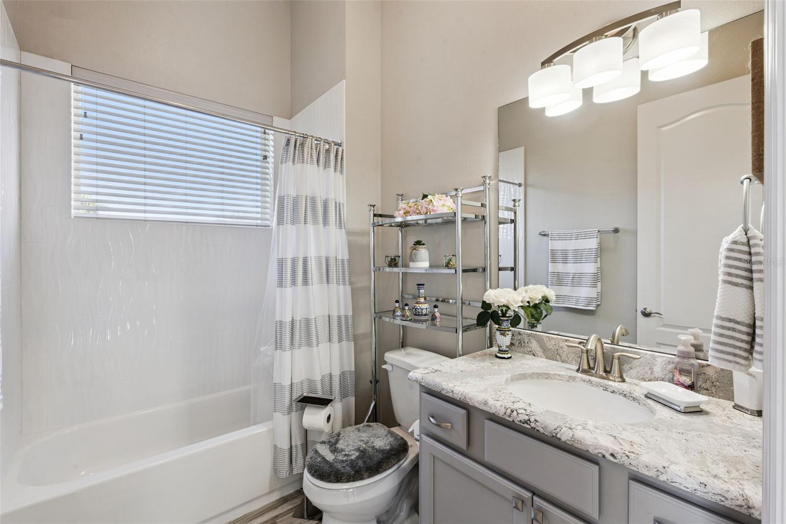 Bedroom 4/in law suite includes an en suite bathroom with shower/tub combo and quartz counters