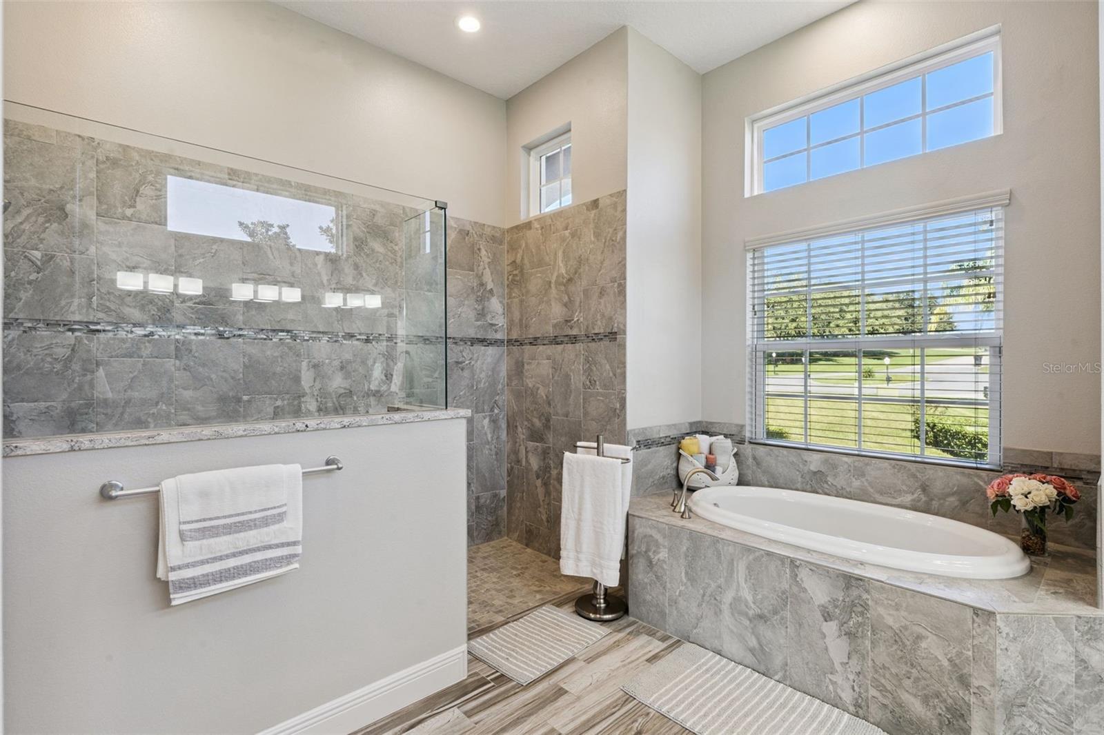 Spacious master en suite featuring a luxurious, zero-entry walk-in shower and a deep soaking tub for ultimate relaxation.