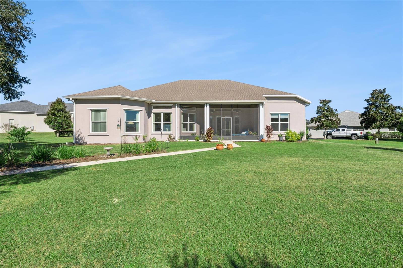 Rear exterior view featuring a paver walkway leading to the water.