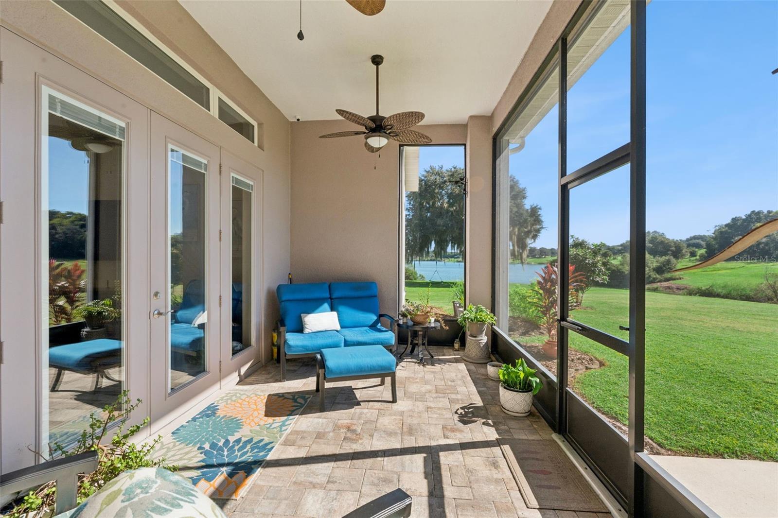 Covered lanai with pavers overlooking the water
