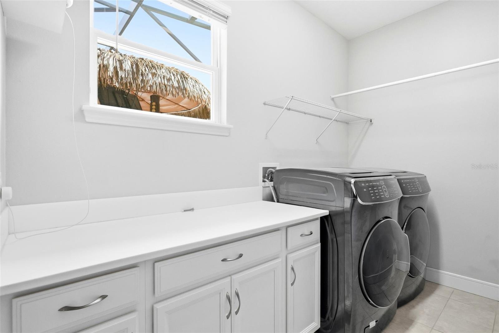 Laundry room features cabinet and counter space along with a washer and dryer