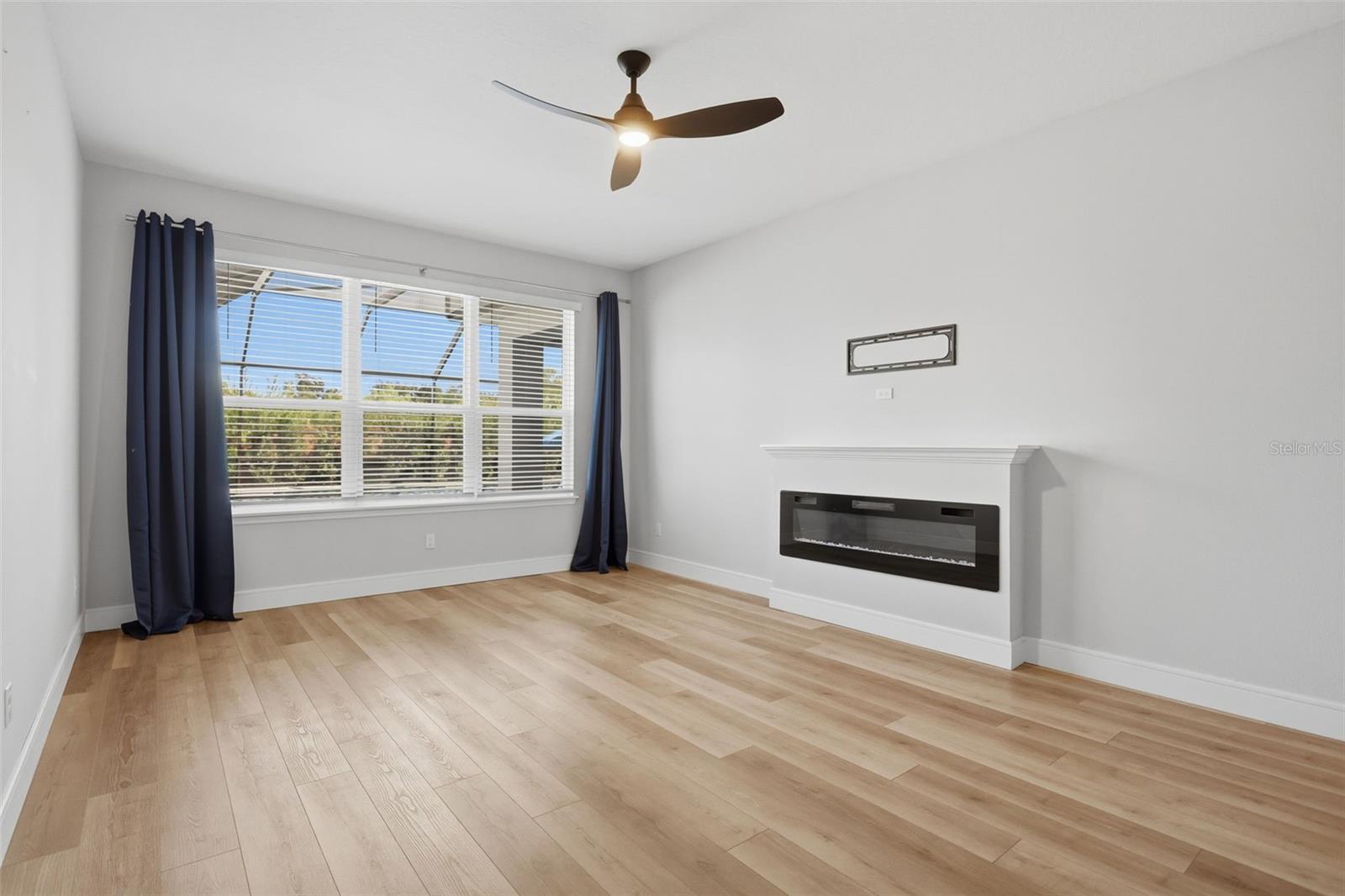 Primary bedroom downstairs features a fireplace and large windows providing a view of the pool