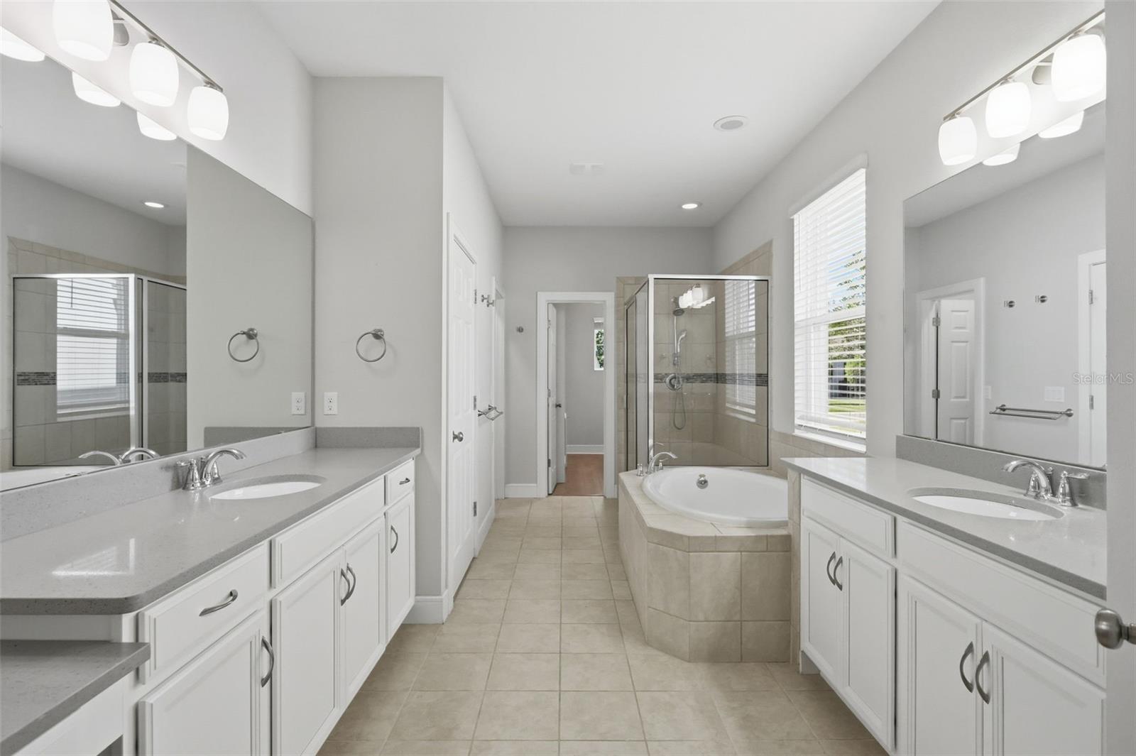 Primary bathroom features two vanities, 2 walk-in closets, garden tub and large shower