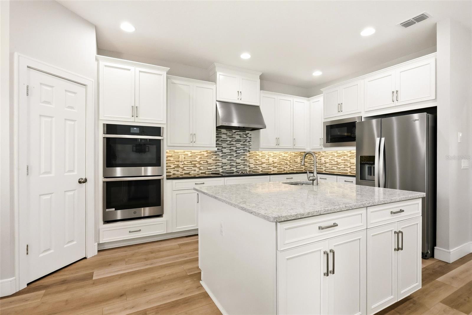 Double ovens in the kitchen with a prep island