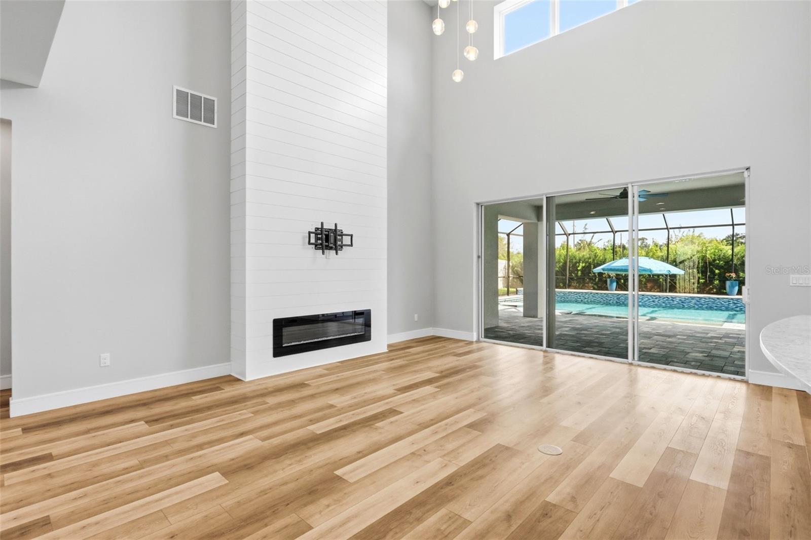 Soaring ceilings the the living area with sliding doors out to the covered lanai and enclosed pool.