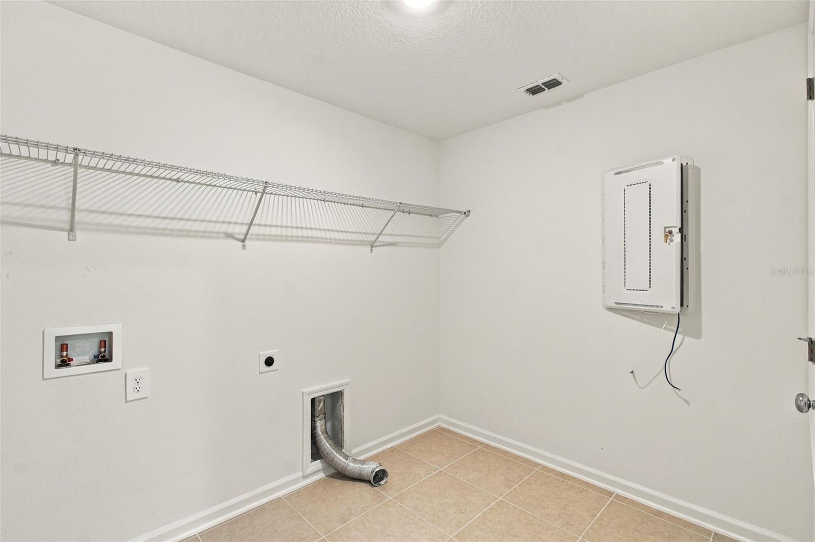 . A spacious laundry room just off the garage offers added convenience and wire shelving for storage.