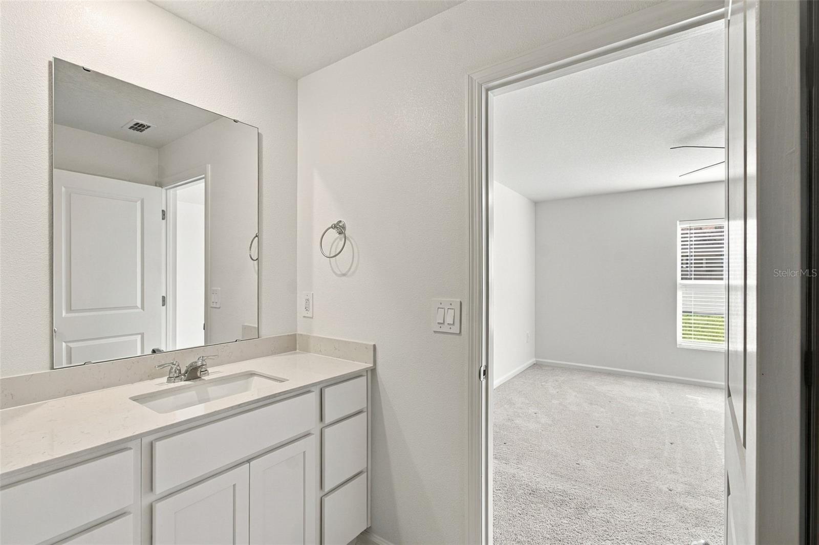 The private owners suite is tucked away at the back of the home and features an en-suite bathroom with dual sinks, a walk-in shower, and a generous walk-in closet.