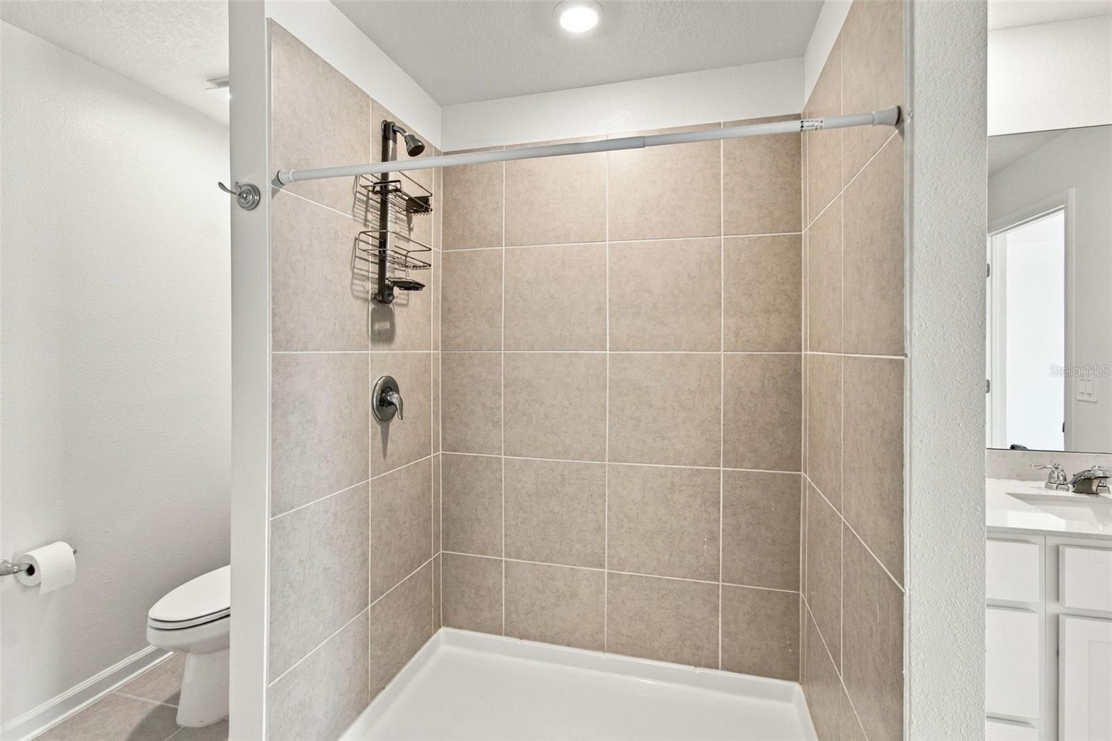 The private owners suite is tucked away at the back of the home and features an en-suite bathroom with dual sinks, a walk-in shower, and a generous walk-in closet.