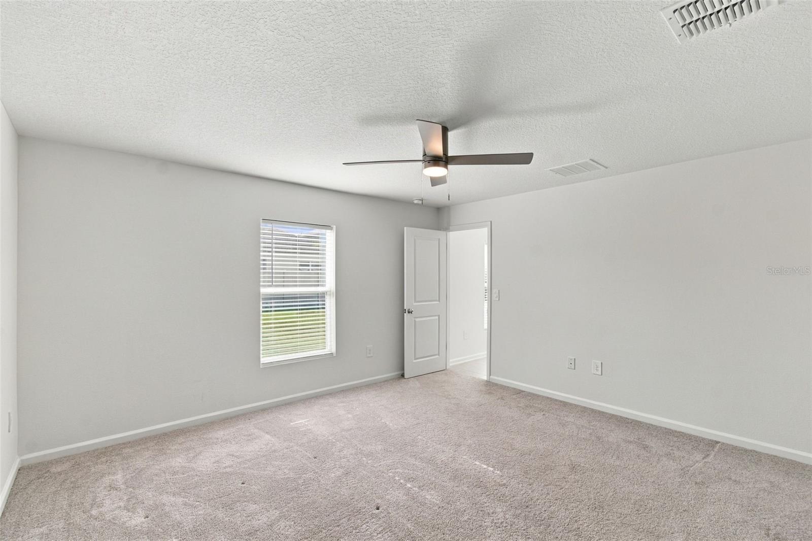 The private owners suite is tucked away at the back of the home and features an en-suite bathroom with dual sinks, a walk-in shower, and a generous walk-in closet.