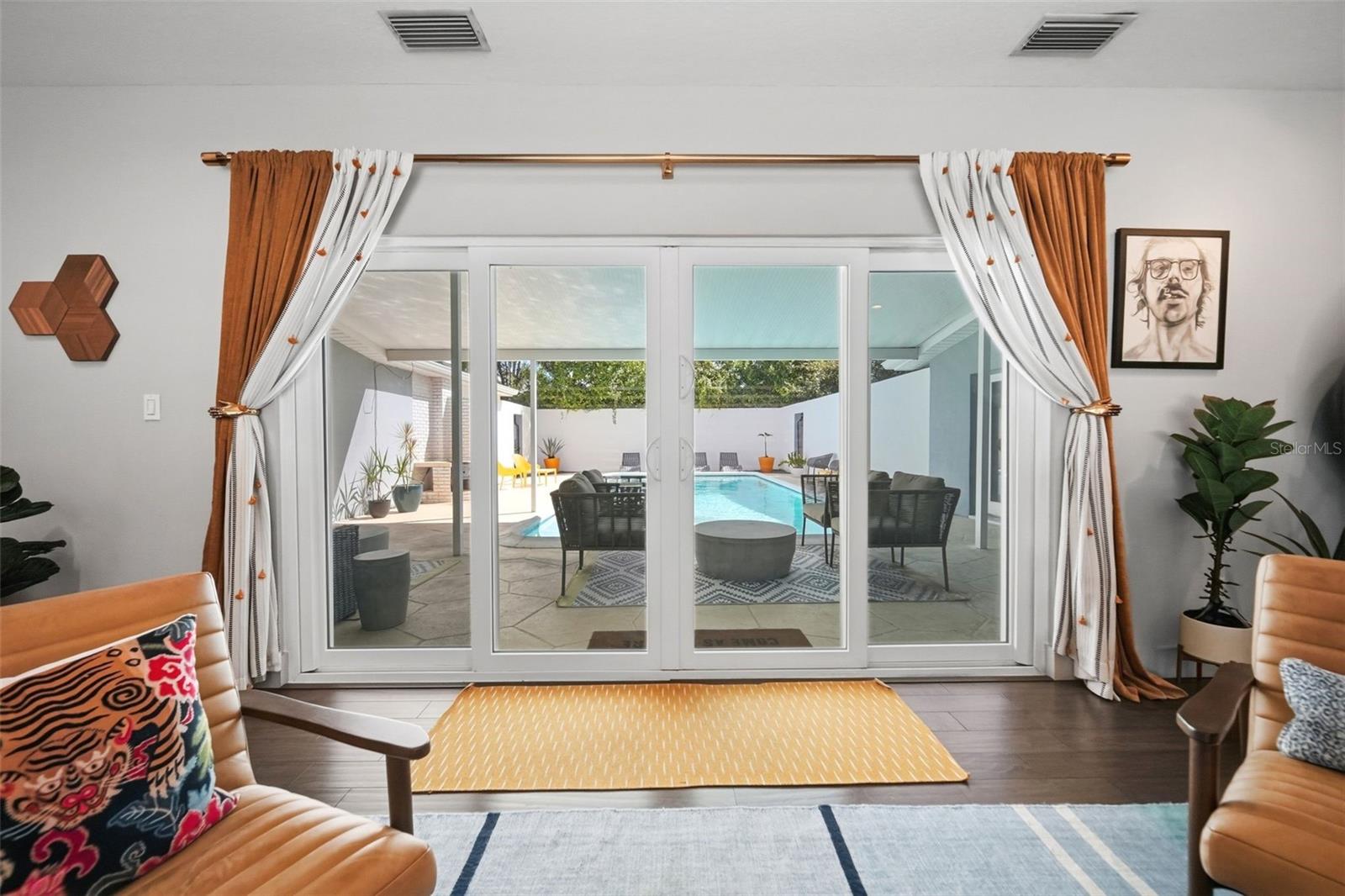 Sliders lead from the living room to the courtyard and pool
