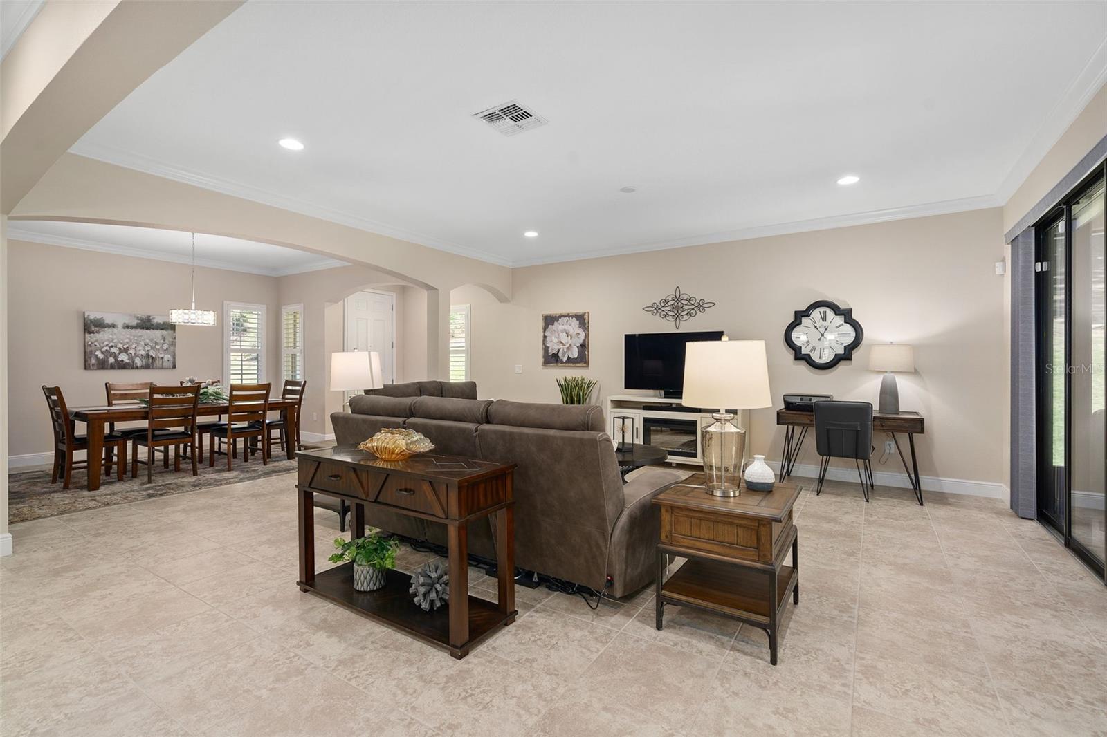 Family and Dining Rooms featuring Architectural Arches and Upgraded Ceramic Tile flooring. There is a Floor Electrical Receptacle in the Family Room for your convenience.