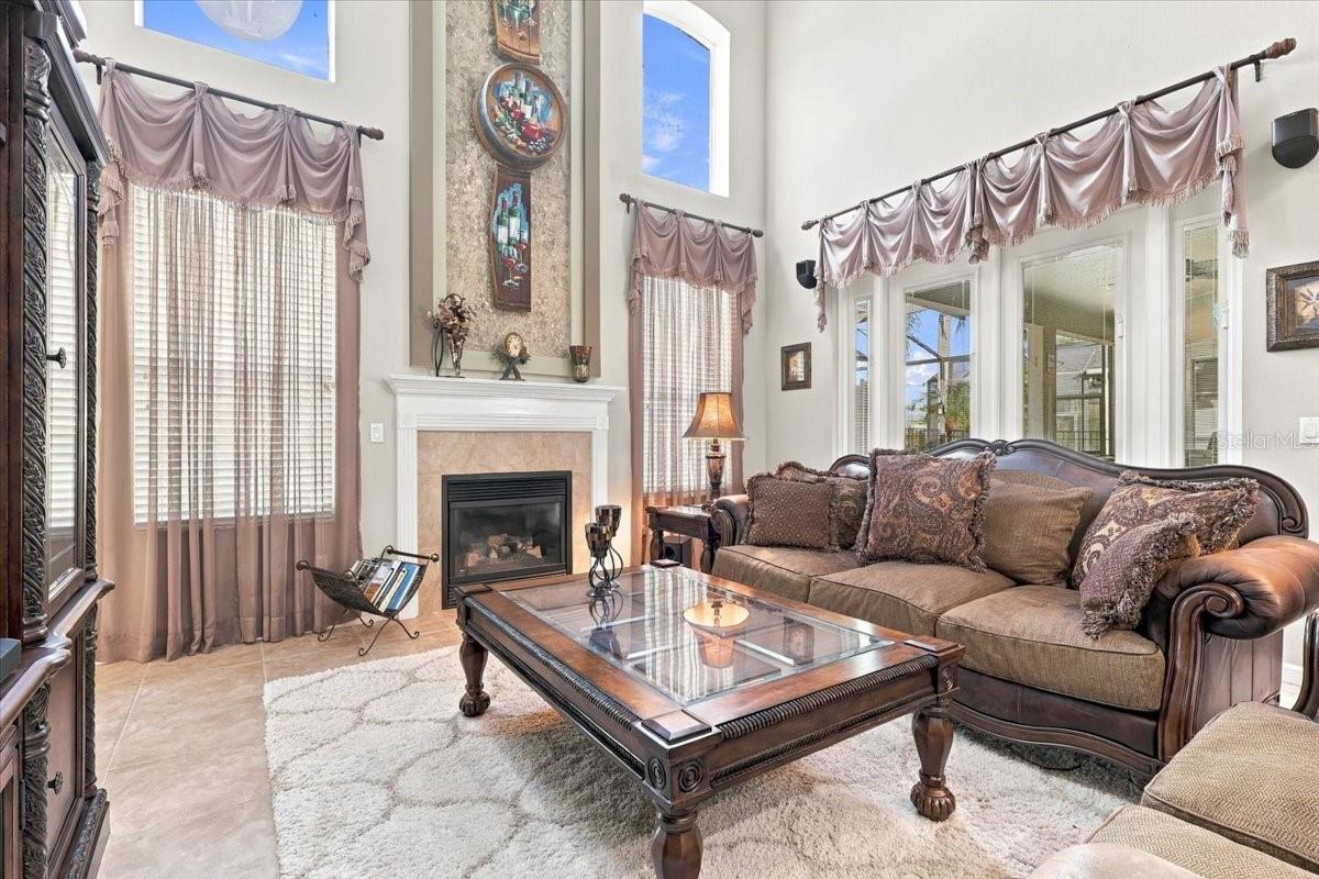 Two story living room is anchored by the fireplace feature wall.