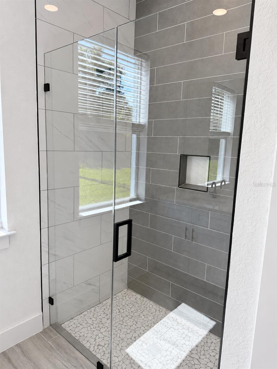 Primary glass shower. Actual property photo, digitally refined.