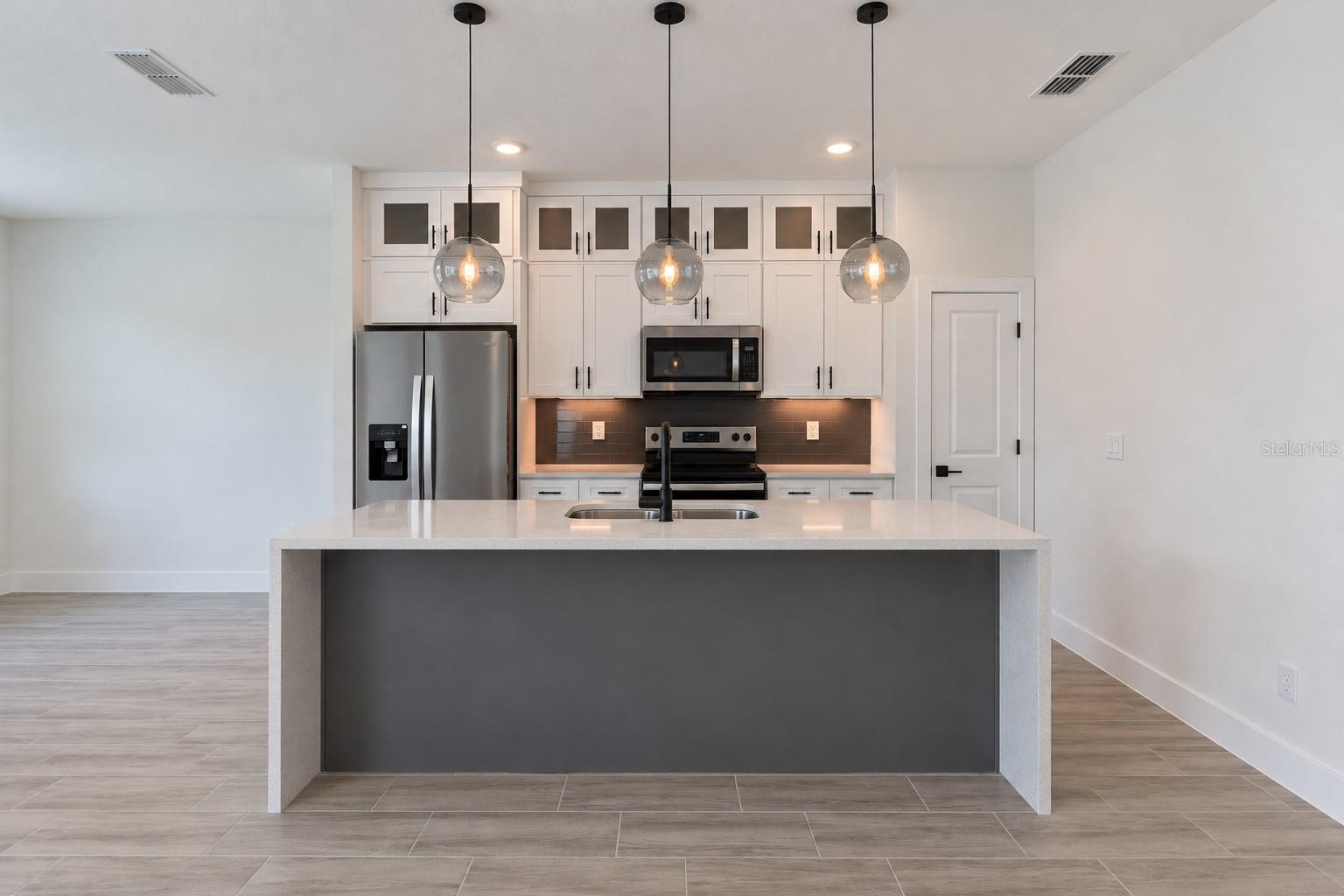 Kitchen front view. Digitally edited model/property composite.