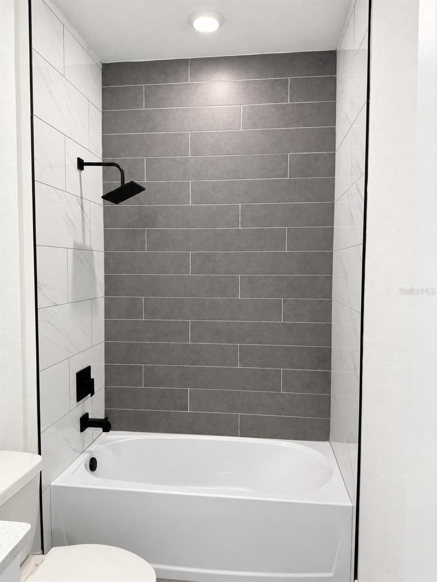 Guest tub and tile detail. Actual property photo, digitally refined.
