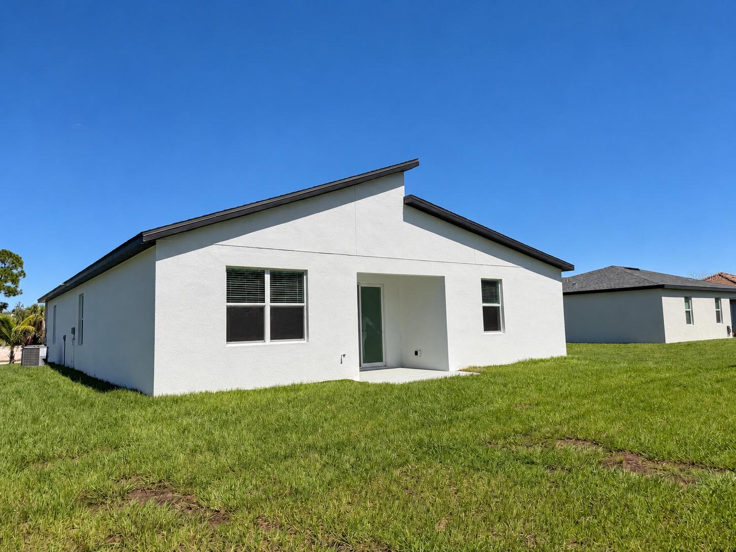 Rear exterior. Actual property photo, digitally refined.