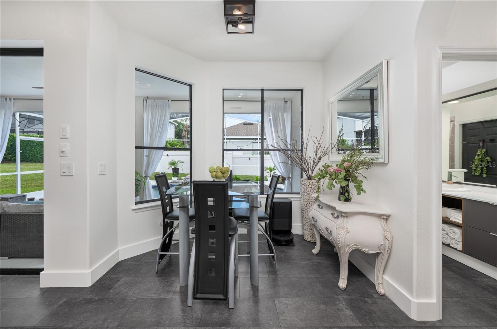 Bright and inviting breakfast nook with a picturesque view of the pool.
