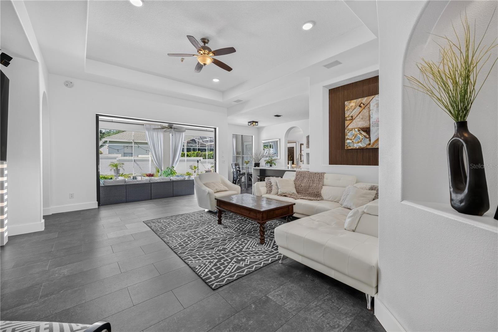 Expansive sliding glass doors open fully, seamlessly extending the living area to the outdoors and creating an ideal space for entertaining.