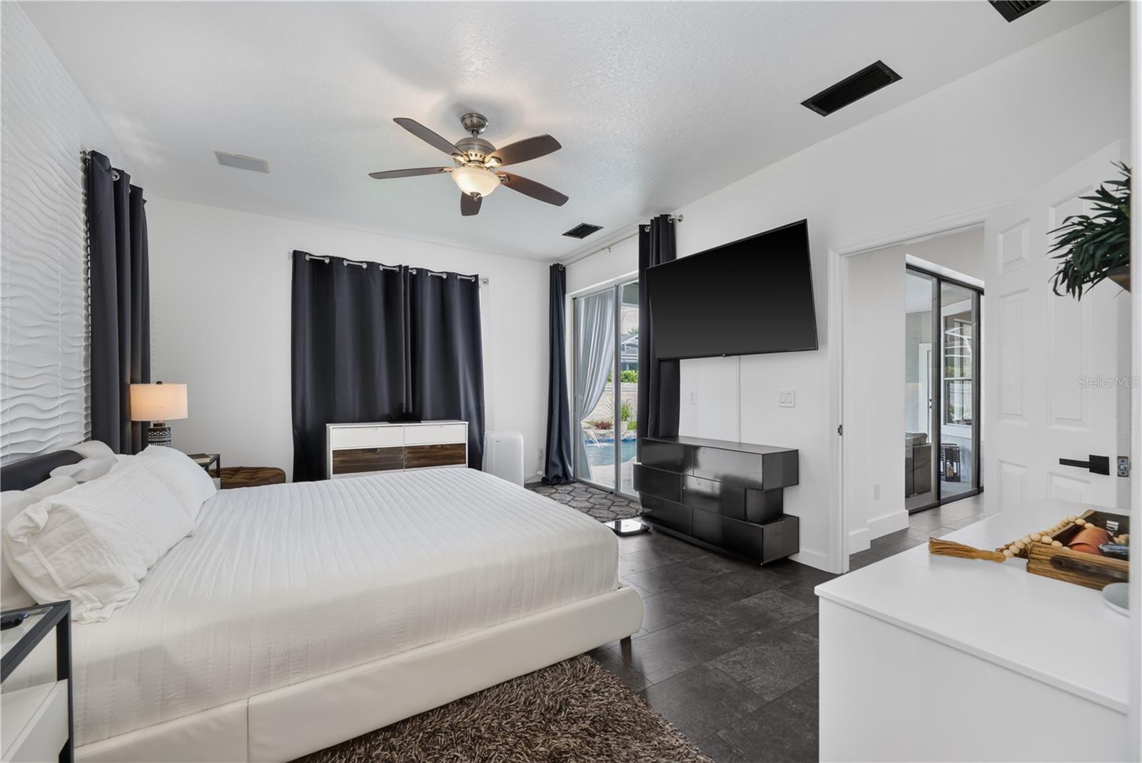 Spacious primary bedroom with a scenic view of the pool.