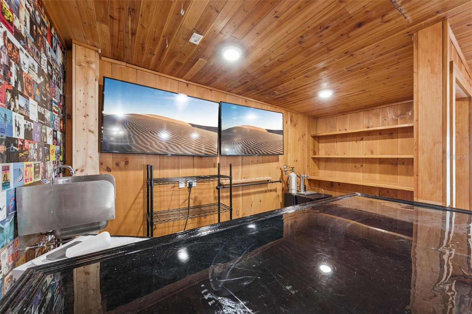 Looking into the bar area with fixed shelving, epoxy bartop and sink with 2 flat screen tv's included.  Everything you need to start watching the big game!