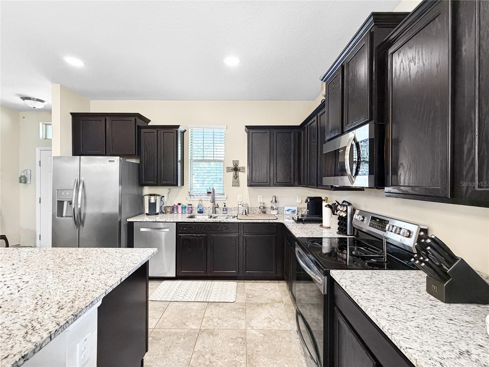 Classic espresso cabinetry, granite counters and stainless appliances