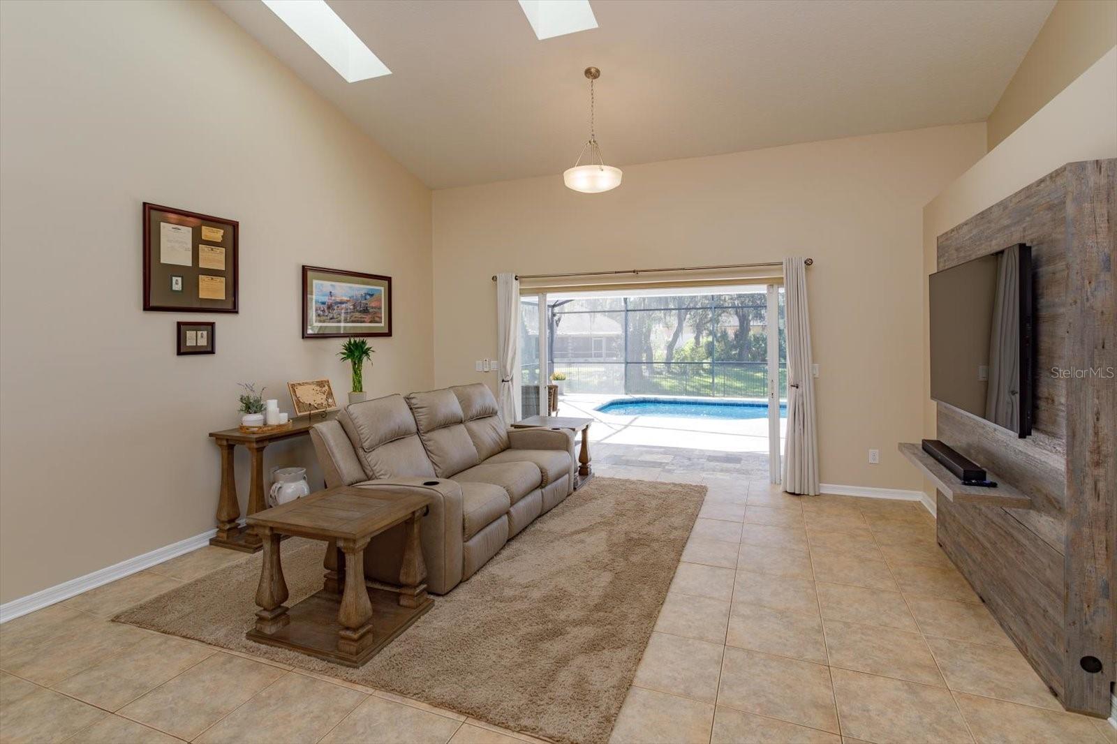 Freshing painted family room features double pocket sliding doors to the covered porch