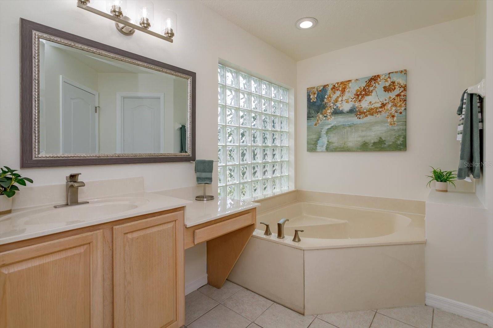 Her primary bathroom features corner tub, knee space and private water closet