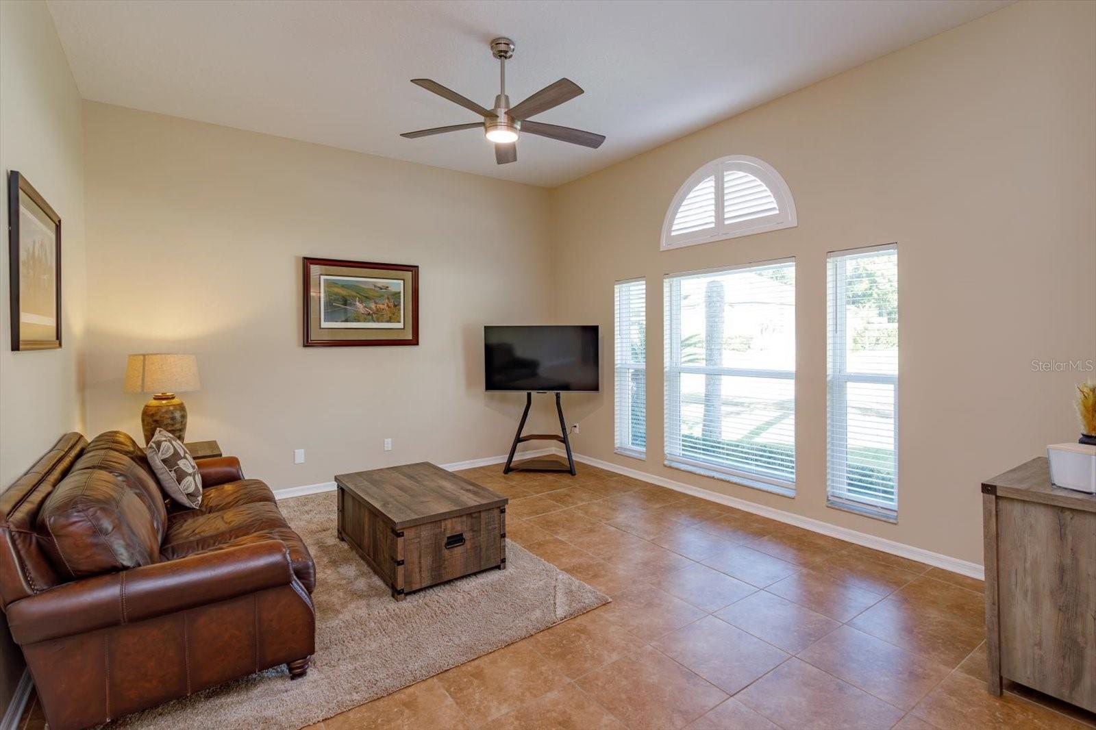 Freshly painted living room with new windows and new ceiling fan