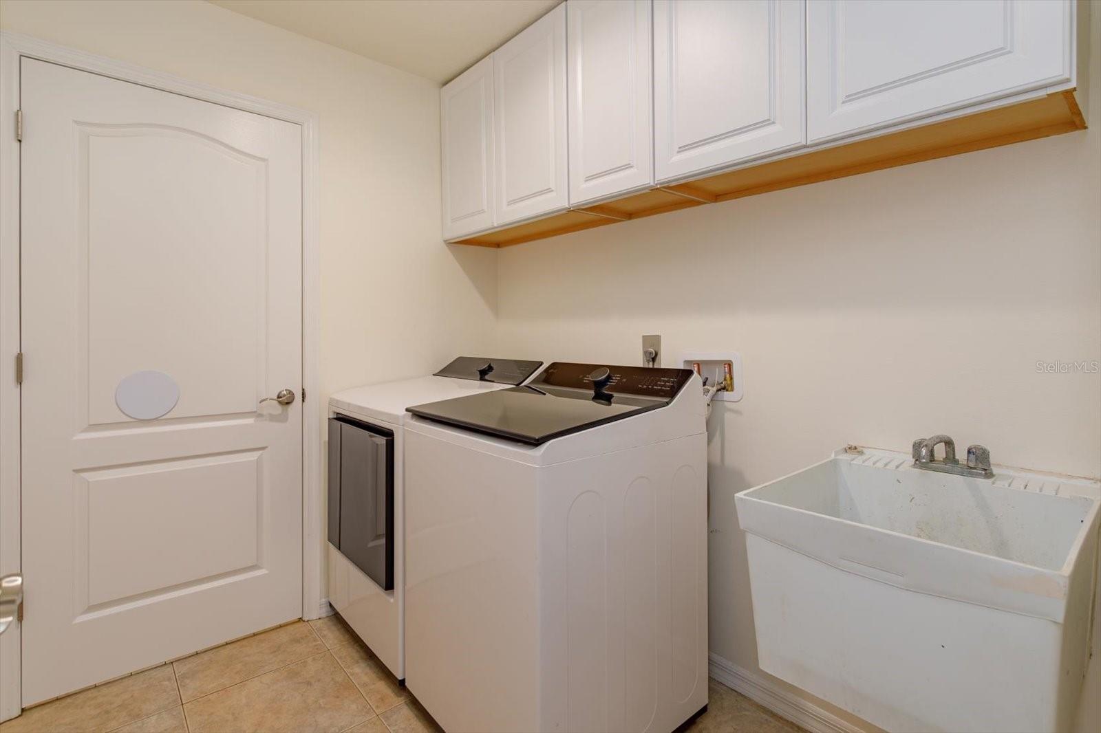 Laundry room with built in cabinets and sink