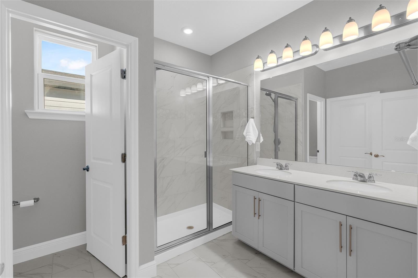 Primary bathroom with dual-sink vanity and glass-enclosed shower