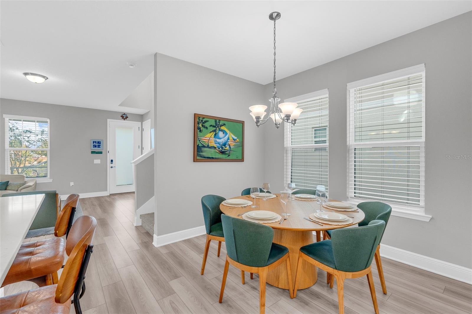 Open dining area with windows overlooking the side yard