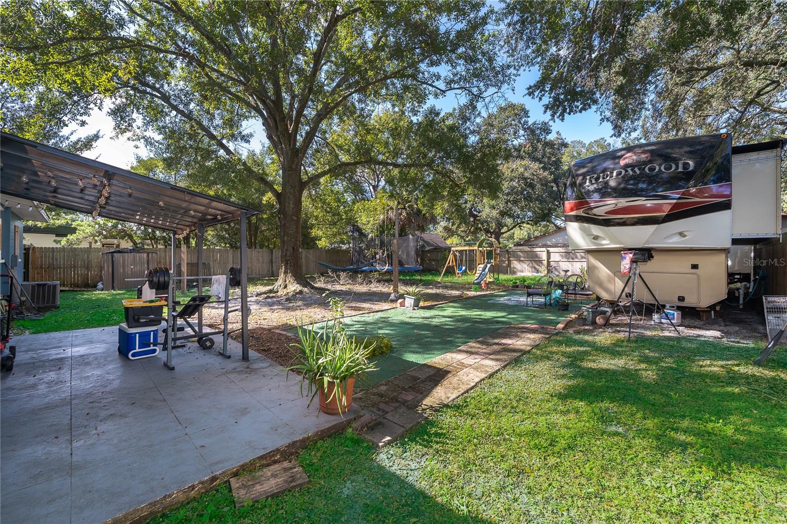 Step outside and discover a spacious backyard with mature trees, a patio area, and plenty of room to enjoy the outdoors.