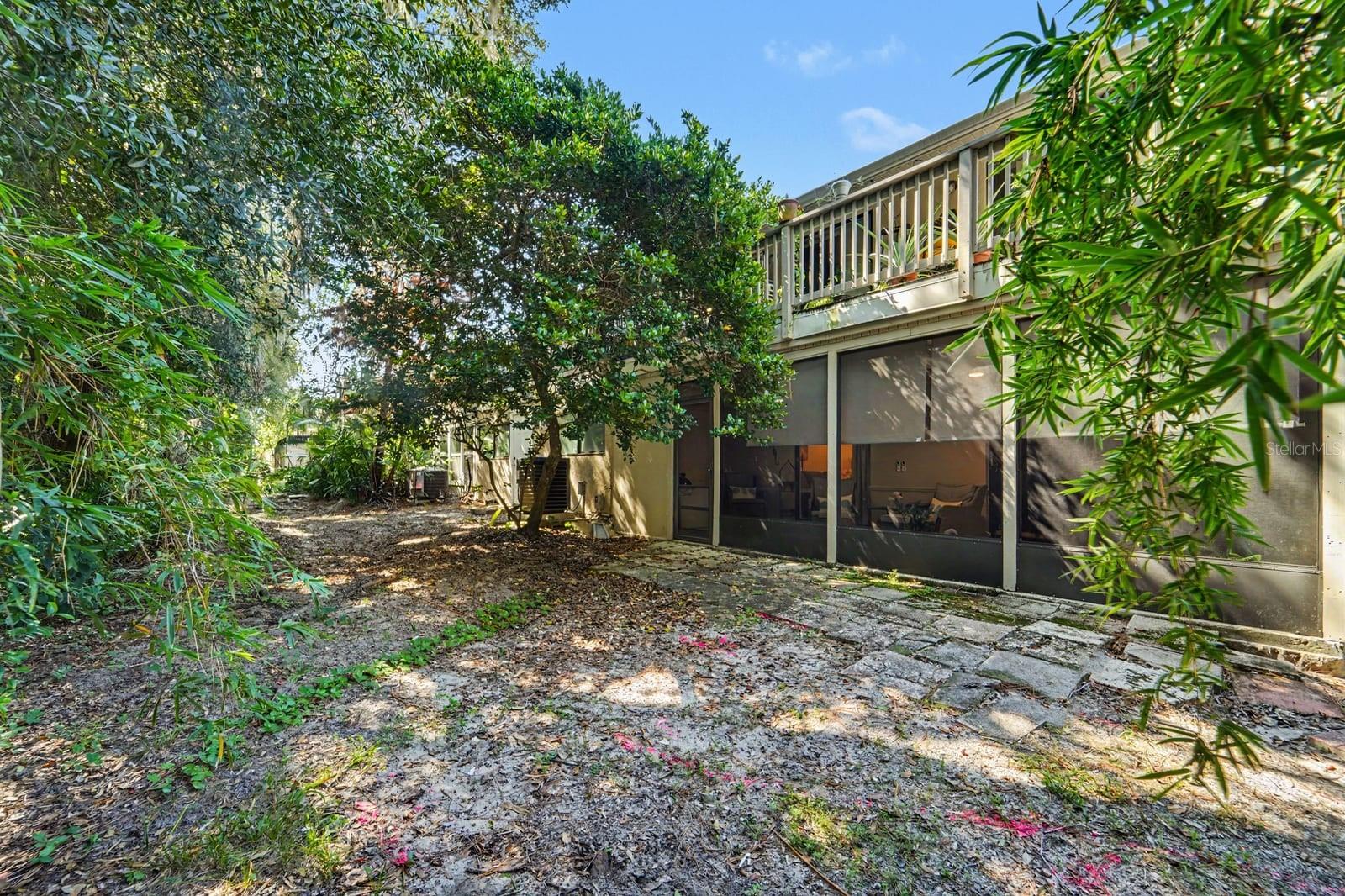 Lush tropical landscaping surrounds the spacious rear exterior and pool area