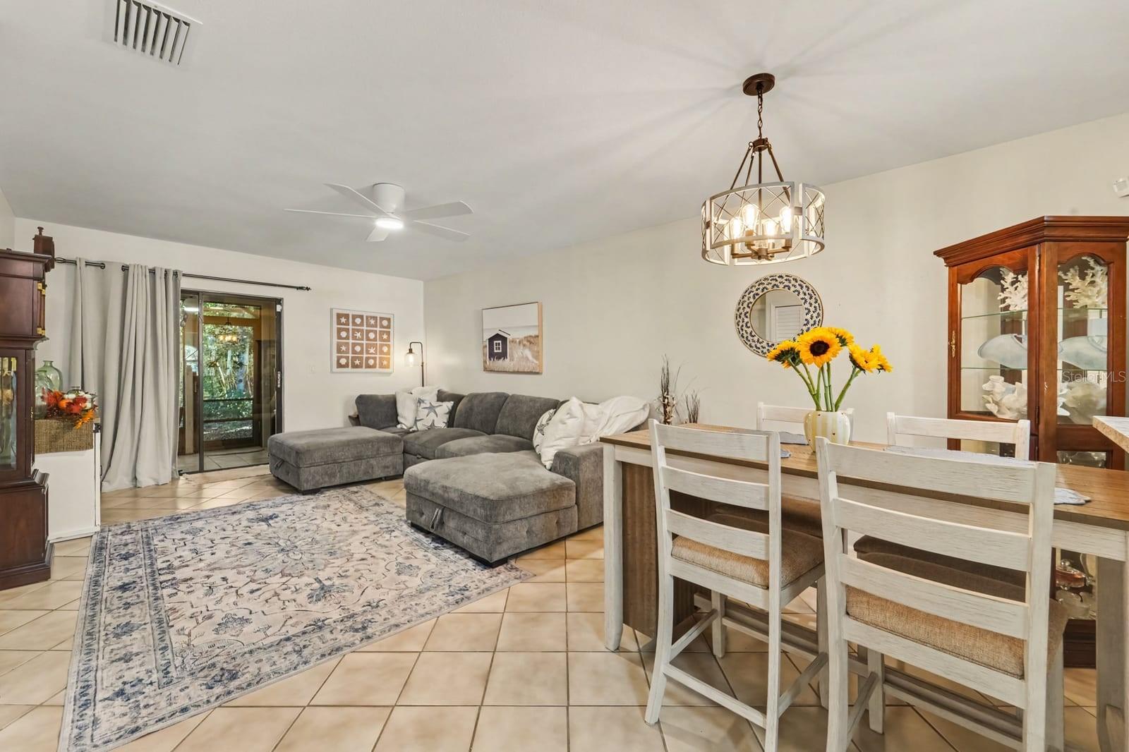 Dining and Living Spaces Flow Together with Pendant Lighting and Display Cabinet Dining and Living Spaces Flow Together with Pendant Lighting and Display Cabinet