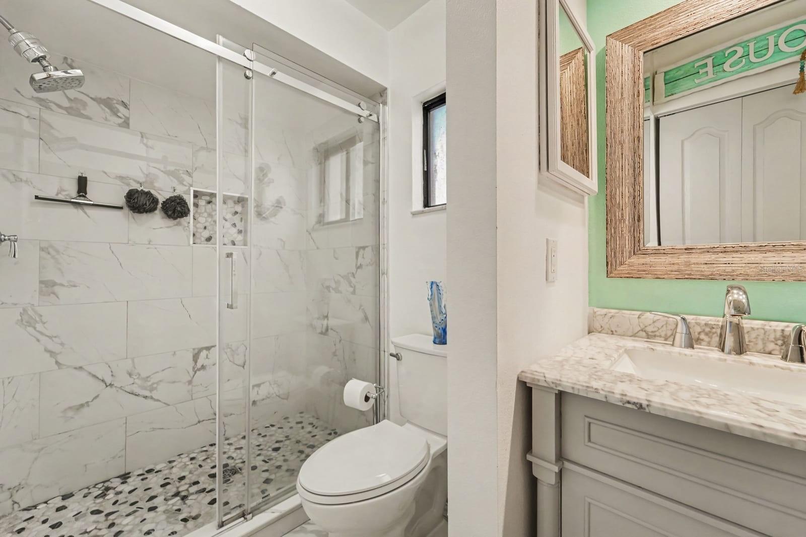Bright ensuite bathroom with marble finishes and custom cabinetry