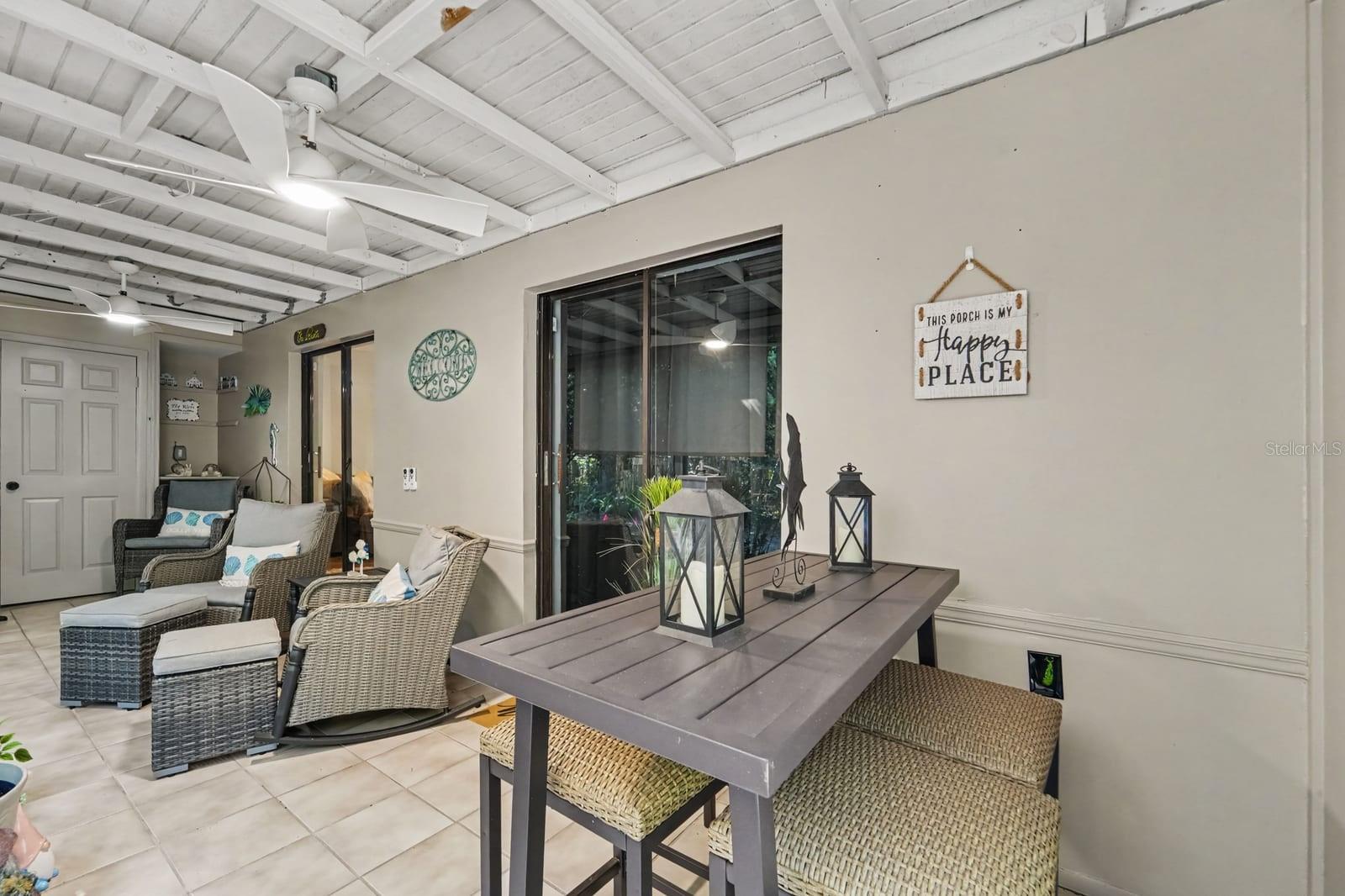 Covered lanai with exposed beam ceiling opens to patioideal for indoor-outdoor living